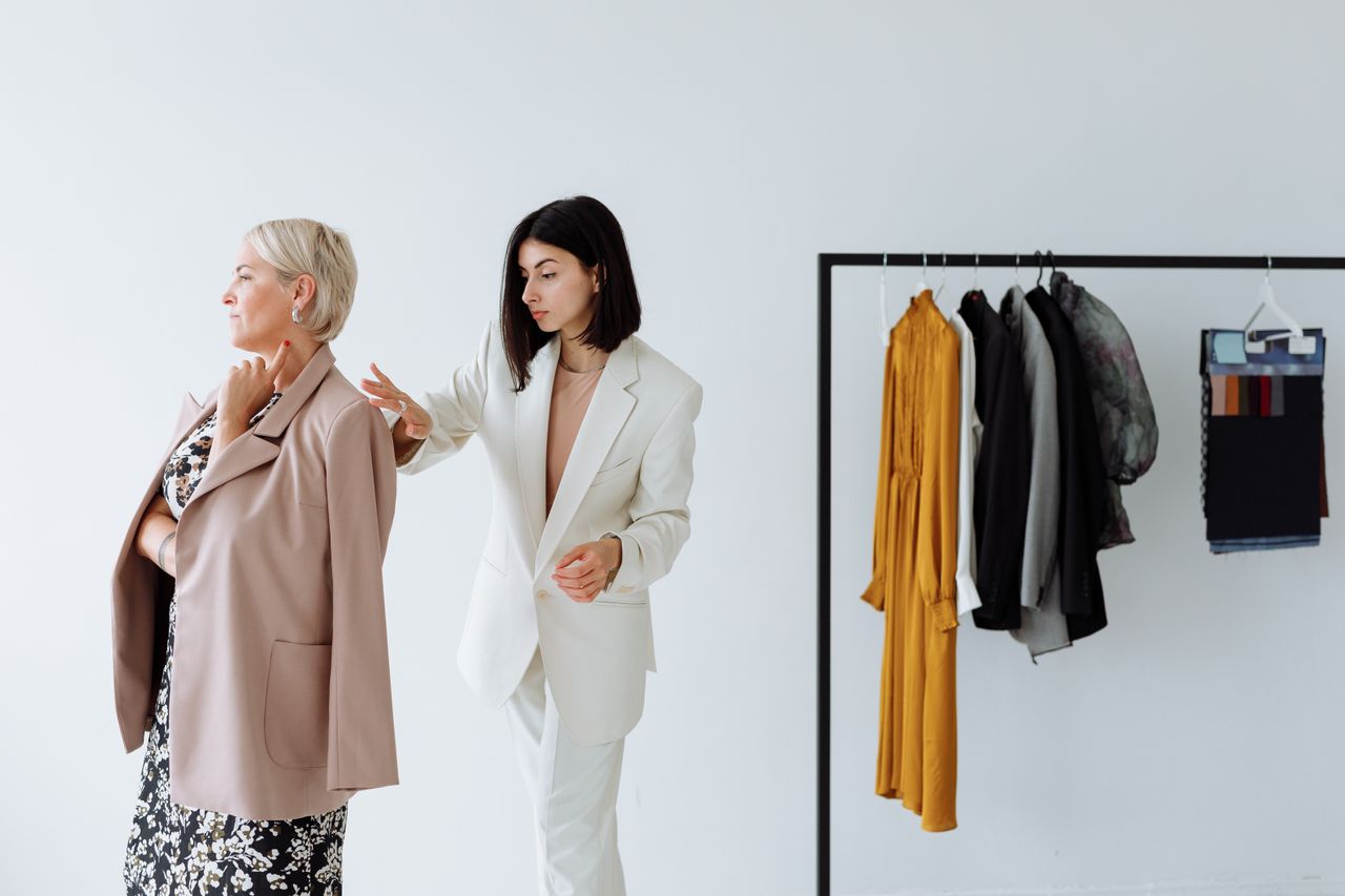 Mastering the First Impression: Your intriguing post title goes here A fashion stylist helps a woman choose clothing in a stylish boutique setting.